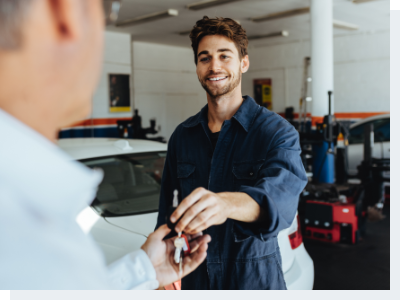 A mechanic handing keys to the owner of the car