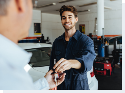 Mechanic Giving Keys to Happy Customer A mechanic handing keys to the owner of the car