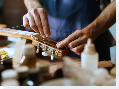 Male hands repairing a guitar