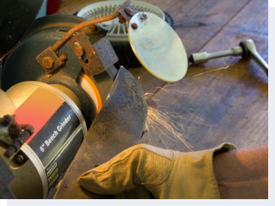 Mechanic sharpening a lawnmower blade