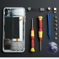 smartphone repair flatlay opened iPhone with tools lying beside it