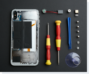 opened iPhone with tools lying beside it