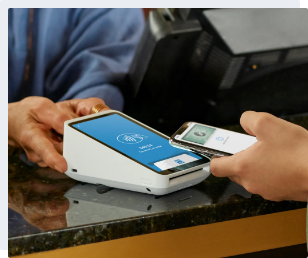 Square Terminal in action Customer paying with phone and Square payment terminal